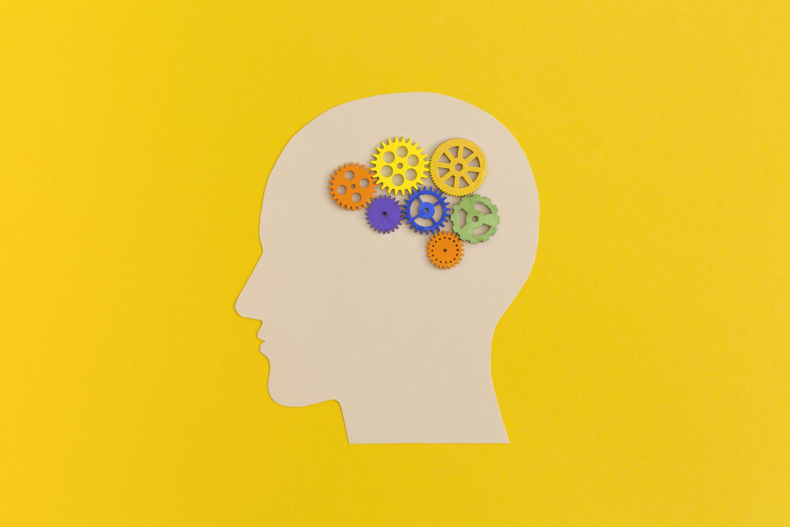 Human head with gears on yellow background